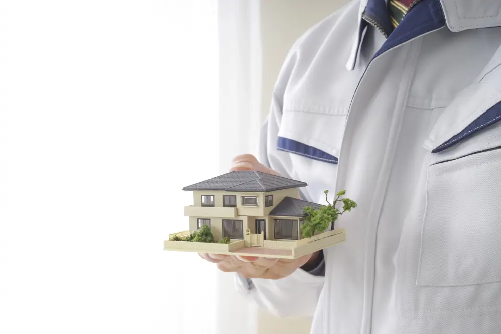 男性が家の模型を持つ